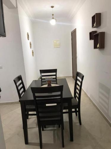 una sala da pranzo con tavolo e sedie neri di Appartement à louer à azemmour a Azemmour