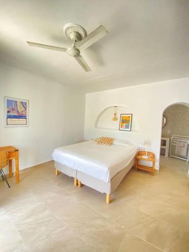 a bedroom with a bed and a ceiling fan at La Finca de Véro in Barbate