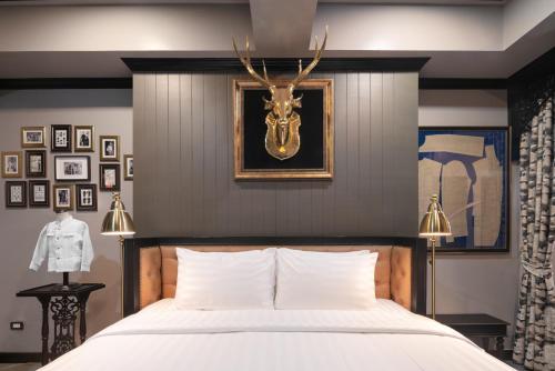 a bedroom with a bed with a deer head on the wall at DE Phanakron Boutique Hotel in Bangkok