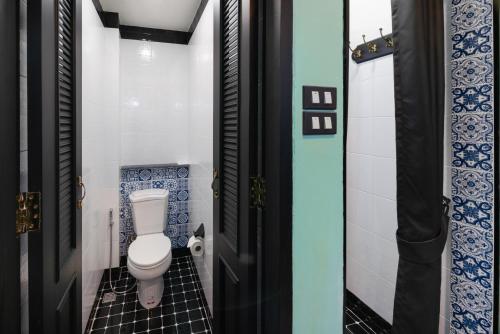 a bathroom with a toilet and blue and white tiles at DE Phanakron Boutique Hotel in Bangkok