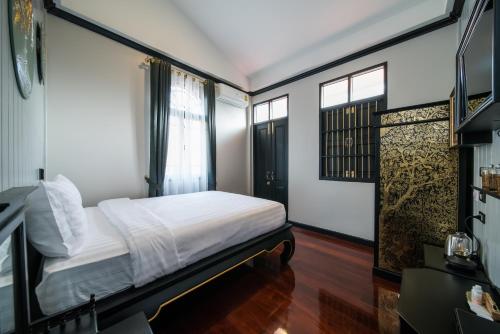 a bedroom with a bed and a window at DE Phanakron Boutique Hotel in Bangkok