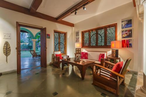 a living room with a table and chairs at SaffronStays Aquamarina in Nagaon