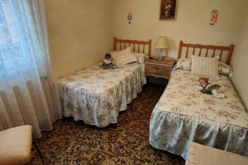 zwei Betten in einem Zimmer mit zwei Teddybären drauf in der Unterkunft casa lucia in Palencia