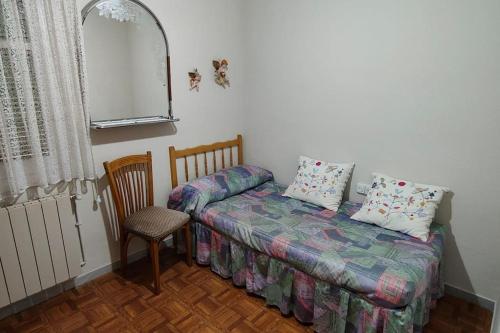 ein Schlafzimmer mit einem Bett, einem Stuhl und einem Fenster in der Unterkunft casa lucia in Palencia