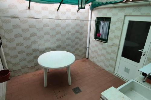 Una pequeña mesa blanca en una habitación con ventana en casa lucia en Palencia
