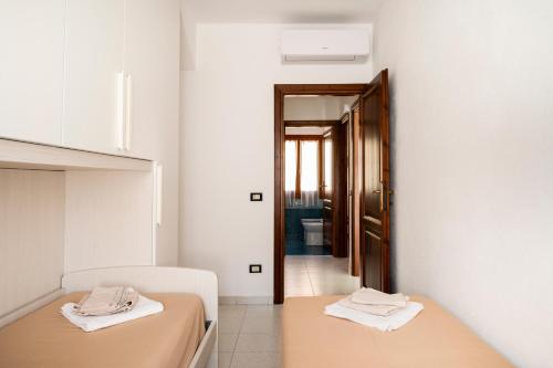two beds in a room with a hallway at Casa Stellins in Santa Teresa Gallura