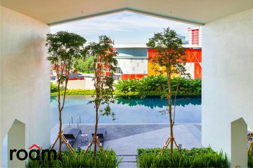 Blick auf den Pool von einem Gebäude mit Bäumen in der Unterkunft UNA Serviced Apartment Kuala Lumpur by Roam in Kuala Lumpur
