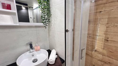 a bathroom with a white sink and a shower at Osada nad Zalewem in Tolkmicko