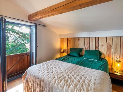 um quarto com uma cama e uma grande janela em gite au chat bûcheron em Vienne
