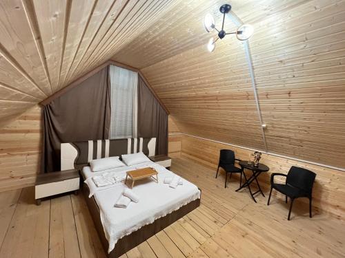 ein Schlafzimmer mit einem Bett, einem Tisch und Stühlen in der Unterkunft Time House in Kokotauri