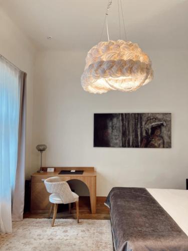 a bedroom with a bed and a chair and a chandelier at Dome Hotel in Rīga