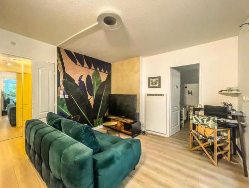 a living room with a green couch and a desk at LE BUNKER Prado Plage Velodrome in Marseille