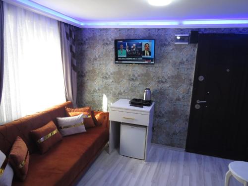 a living room with a couch and a tv on the wall at Fetih Suite Home A3 in Istanbul