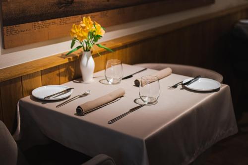 a table with a white table cloth and a vase of flowers at Dome Hotel in Rīga