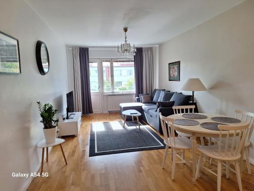 a living room with a table and a couch at City Apartment Kirkkokatu 10, ilmainen kadunvarsipysäköinti in Kuopio