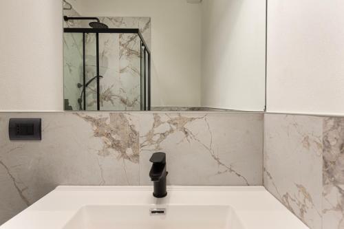 a bathroom with a sink and a mirror on the wall at Aquarama - By Impero House in Feriolo