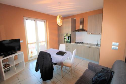 een woonkamer met een tafel en een keuken bij Il sogno di Iaia in Bra