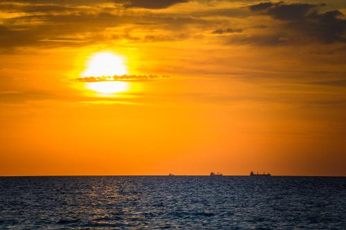 a sunset over the ocean with the sun in the sky at Golden Tulip Międzyzdroje Residence in Międzyzdroje