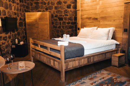 1 dormitorio con 1 cama en una habitación con paredes de madera en Lome Çiftliği Otel ve Restoran en Artvin
