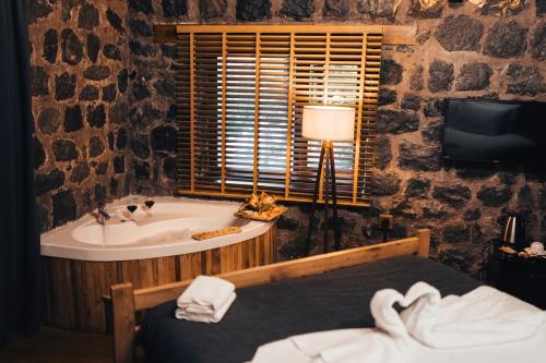 baño con bañera y lavamanos y cama en Lome Çiftliği Otel ve Restoran en Artvin