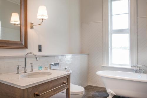 a bathroom with a sink and a tub and a toilet at De Vere Latimer Estate in Chesham