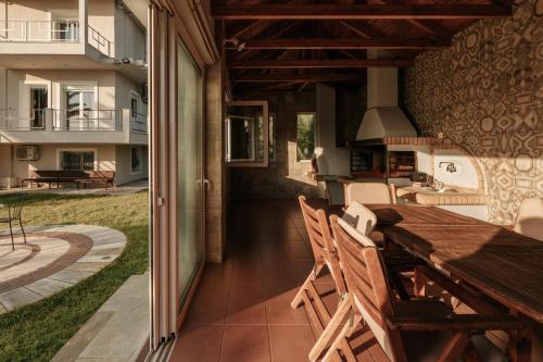 a patio with a wooden table and chairs and a house at Ponte Suites in Antirrio