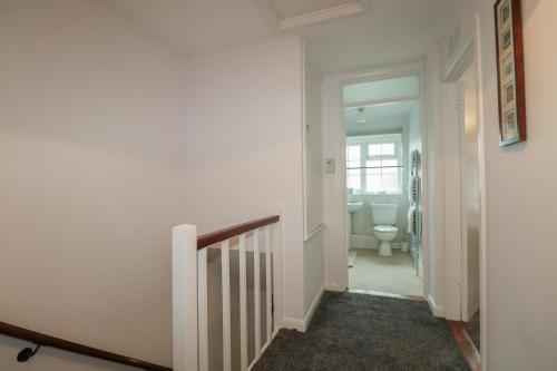 a hallway with a staircase leading to a bathroom with a toilet at 83 Oaklands Road in Havant