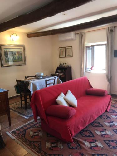 a living room with a red couch and a table at Le Calanque La Terrazza su Civita in Lubriano