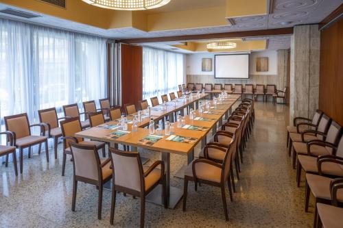 a conference room with a long table and chairs at GHT Oasis Park & Spa in Lloret de Mar