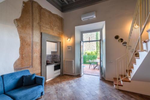 ein Wohnzimmer mit einem blauen Sofa und einer Treppe in der Unterkunft Fabroniana Apartments in Pistoia