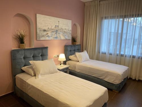 Appartement moderne et spacieux au coeur de Tanger في طنجة: غرفة فندقية بسريرين ونافذة