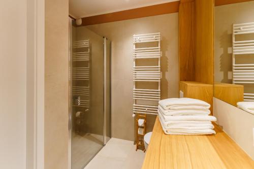 a bathroom with a shower and a table with towels at Apartament SUN SurfingBird Dźwirzyno in Dźwirzyno