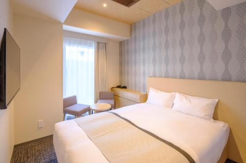 a hotel room with a white bed and a window at Tosei Hotel Cocone Tsukiji Ginza Premier in Tokyo