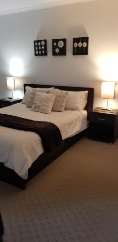 a bedroom with a large bed with two lamps on it at Maison de Chocolate in Broken Hill