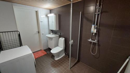 uma casa de banho com um WC e uma cabina de duche em vidro. em Kotimaailma Apartments Vapaudenkatu 40-50 B8 em Jyväskylä