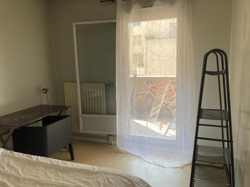 a room with a ladder and a window with a bike at Chambre chez l'habitant à Lyon Centre in Lyon