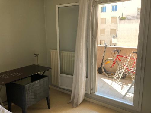 a room with a sliding glass door with a bike outside at Chambre chez l'habitant à Lyon Centre in Lyon