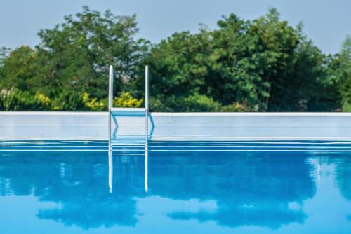 a swimming pool with a chair in the water at I Castagni in Vigevano