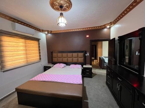 een slaapkamer met een groot bed en een televisie bij Petra luxurious view house in Wadi Musa