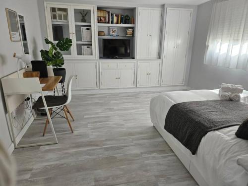 Un dormitorio con una cama, un escritorio y una mesa. en Increíble Apartamento de lujo en Triana, en Sevilla