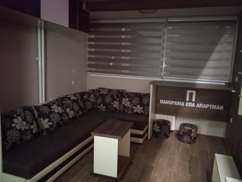 a living room with a couch and a table at PANORAMA SPA apartman in Kraljevo