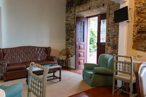 a living room with a leather couch and chairs at Quinta José&Maria Quartos Ferreira do Zêzere in Ferreira do Zêzere