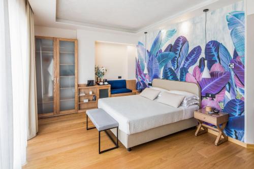 a bedroom with a bed and a colorful mural at Hotel Torino Wellness & Spa in Diano Marina