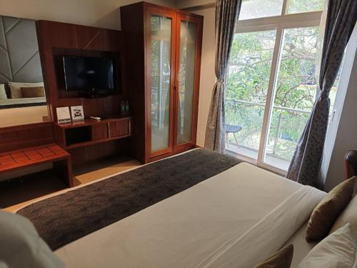 a bedroom with a large bed and a window at De Mandarin in Bengaluru