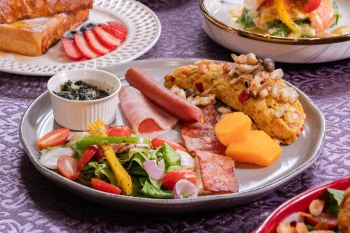 a plate of food with meat and vegetables and bread at DE Phanakron Boutique Hotel in Bangkok