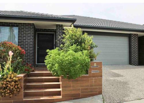 a house with a wooden staircase in front of it at Stay at Linton in Loganlea