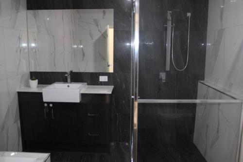 a bathroom with a shower and a sink and a toilet at Stay at Linton in Loganlea