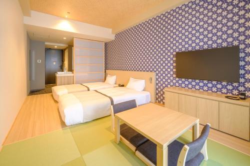 Habitación de hotel con 2 camas y TV de pantalla plana. en Tosei Hotel Cocone Tsukiji Ginza Premier en Tokio