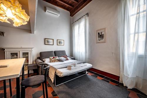 sypialnia z łóżkiem, stołem i oknem w obiekcie Roommo Studio San Gallo we Florencji
