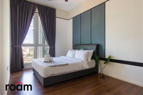 ein Schlafzimmer mit einem Bett und einem großen Fenster in der Unterkunft UNA Serviced Apartment Kuala Lumpur by Roam in Kuala Lumpur